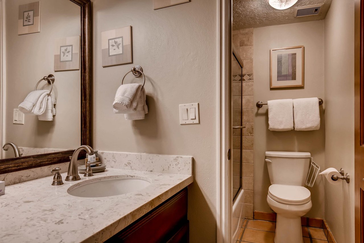 The shared bathroom has a single sink vanity adn separate water closet.