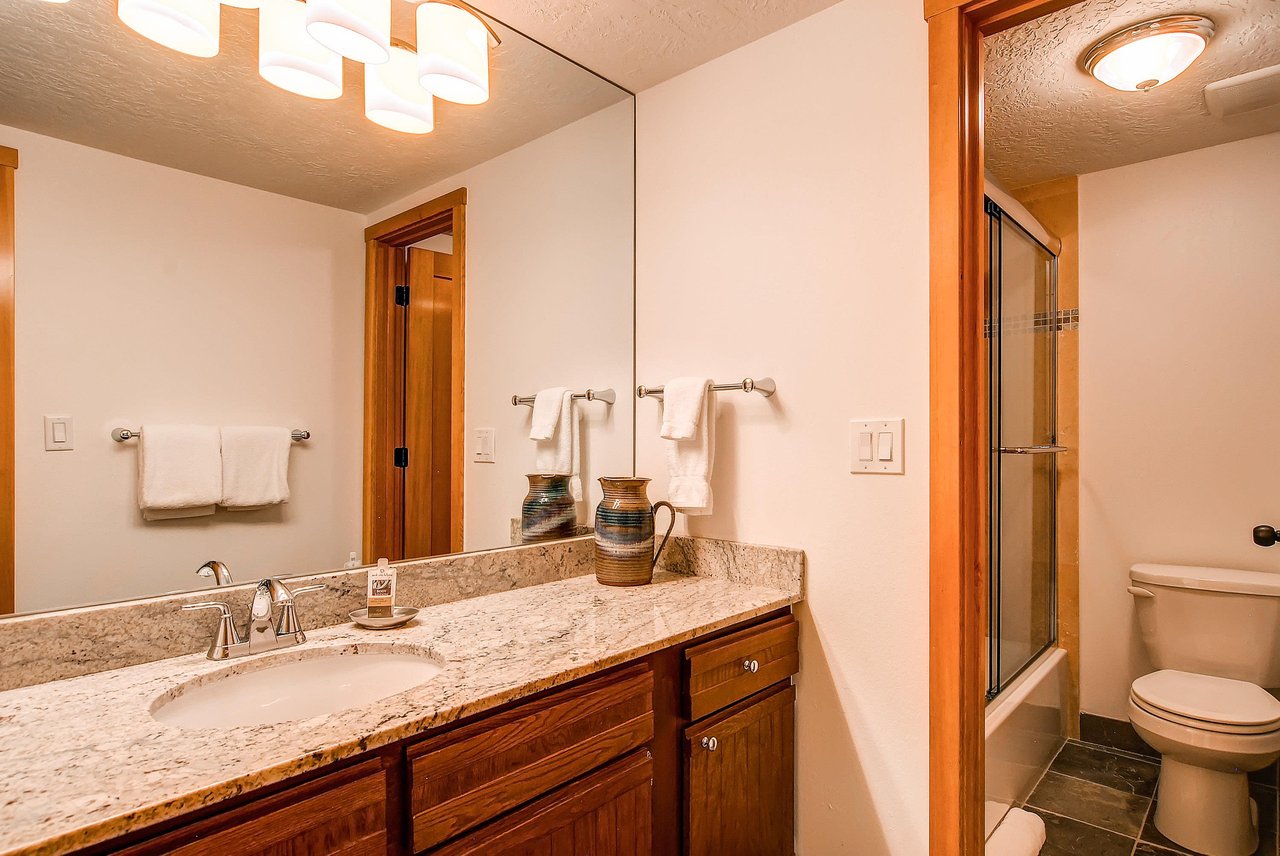 The shared bathroom has a single sink vanity and separate water closet.