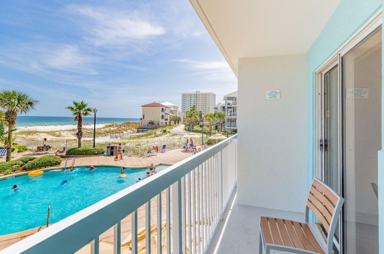 A private balcony with a chair overlooking the pool at Holiday Inn Express in Orange Beach Alabama