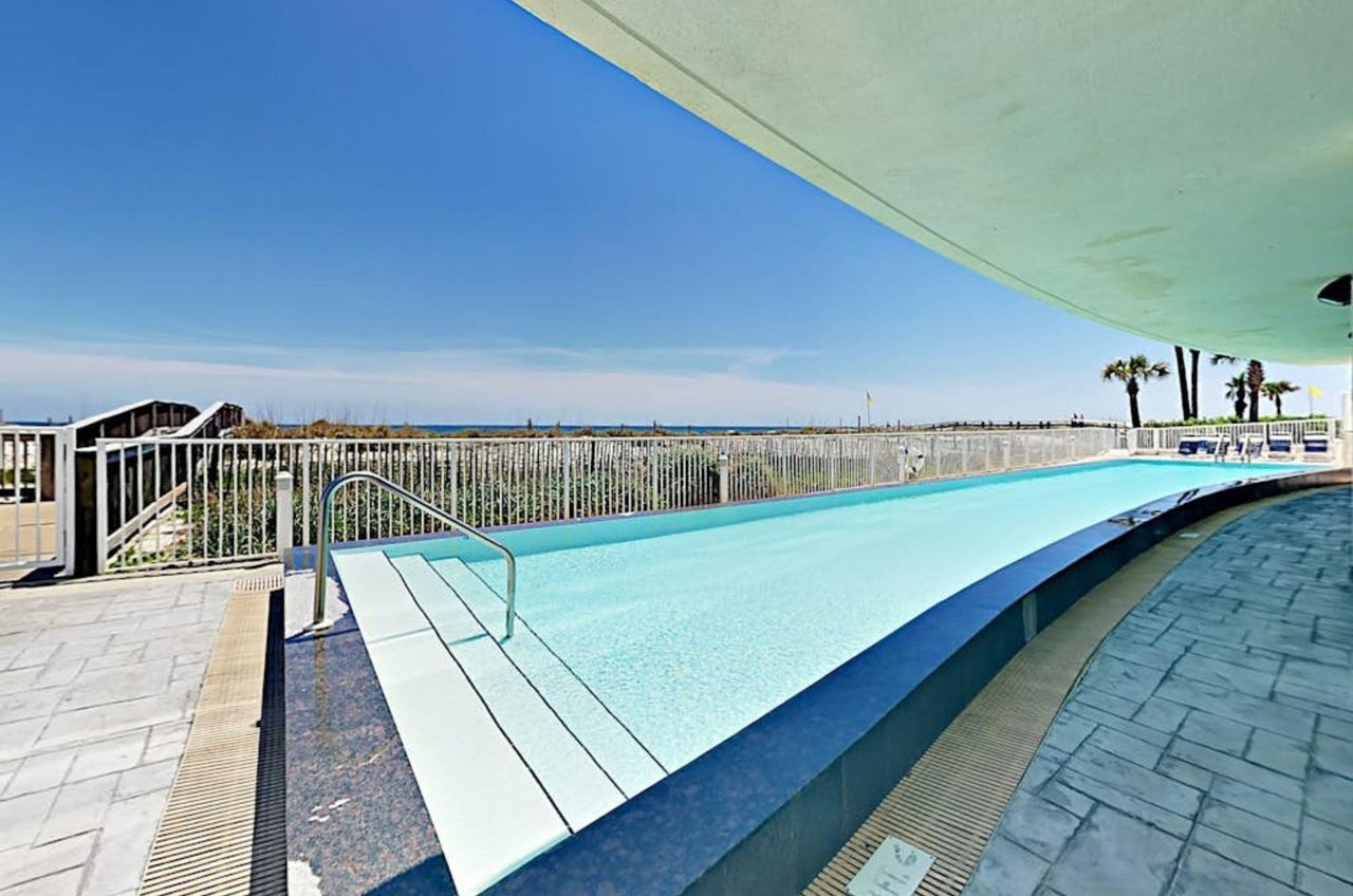 View of the outdoor swimming pool next to the beach at Island Tower in Gulf Shores Alabama