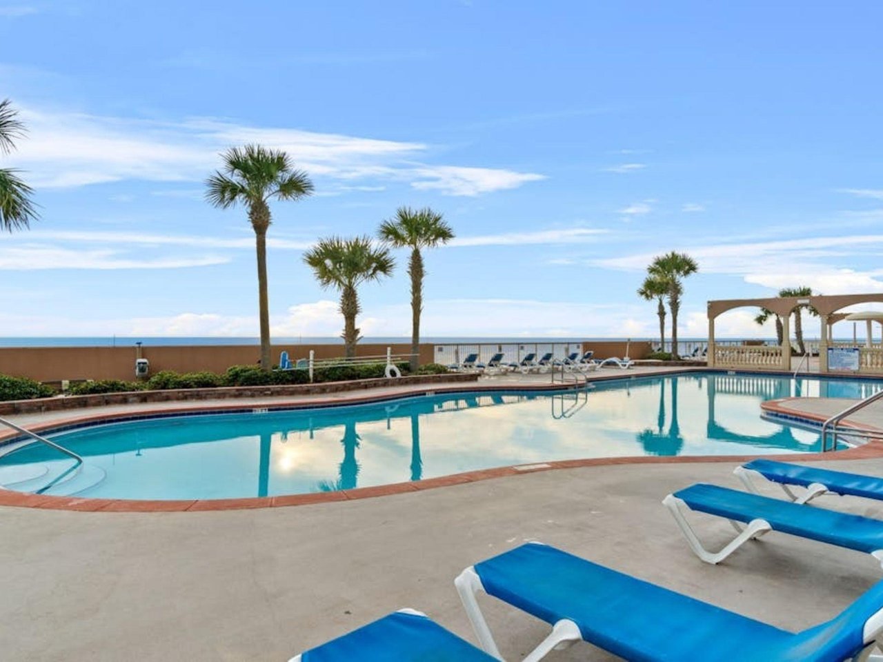 The outdoor swimming pool and pool deck at Sunrise Beach Resort