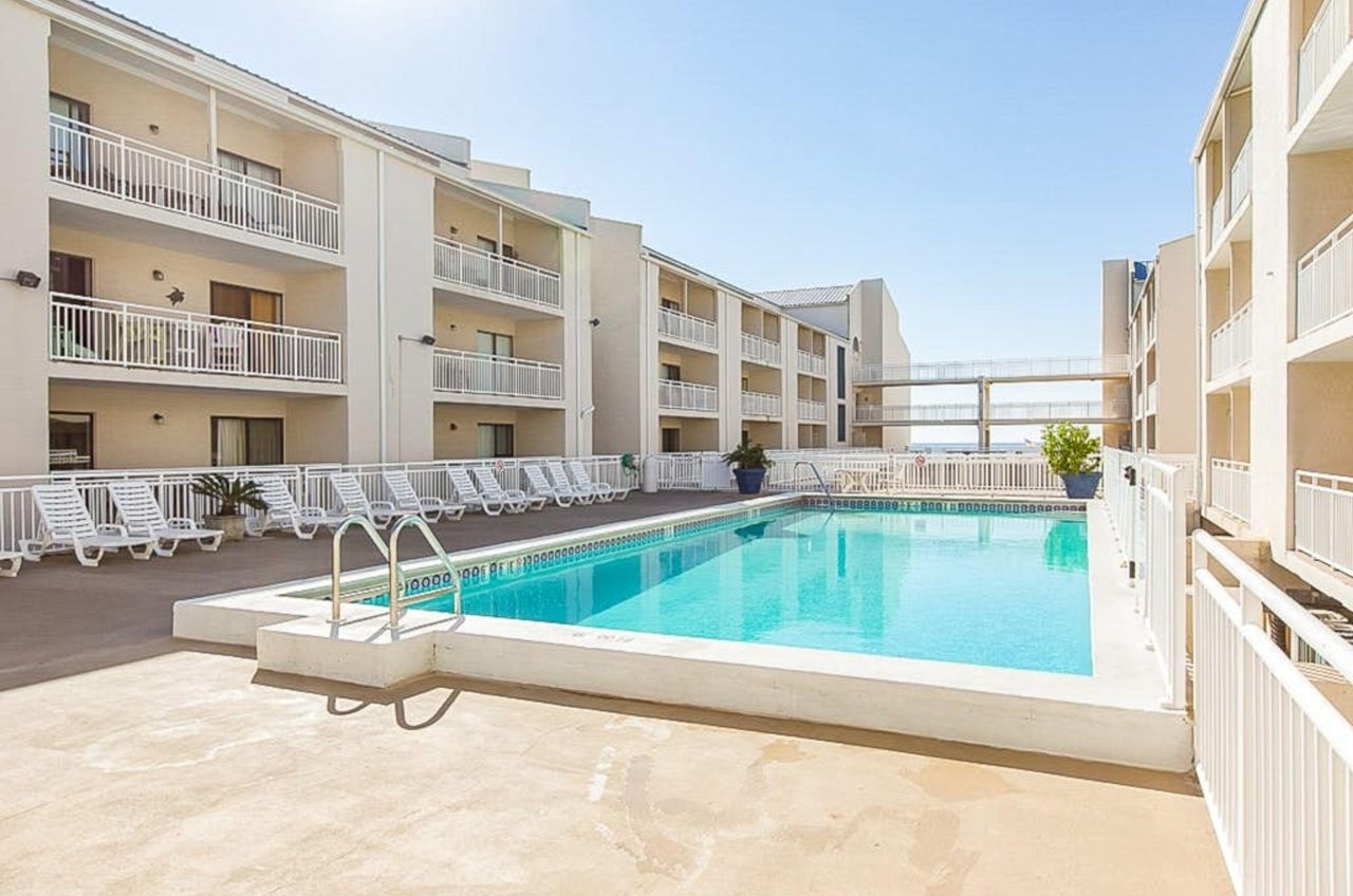 A swimming pool in between the two buildings at Sugar Beach Condos in Orange Beach Alabama