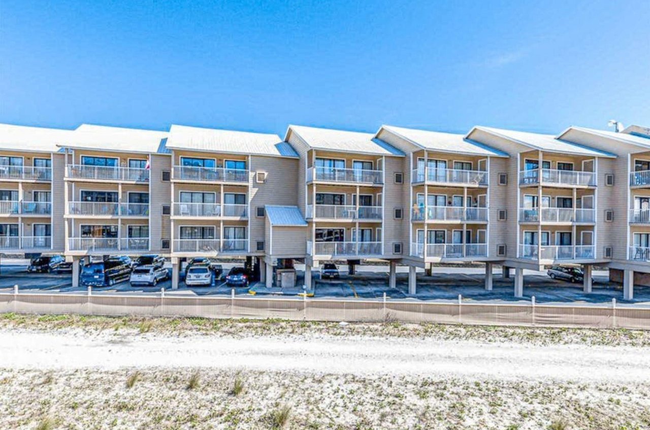 View from the street of Sugar Beach Condos with parking under the building