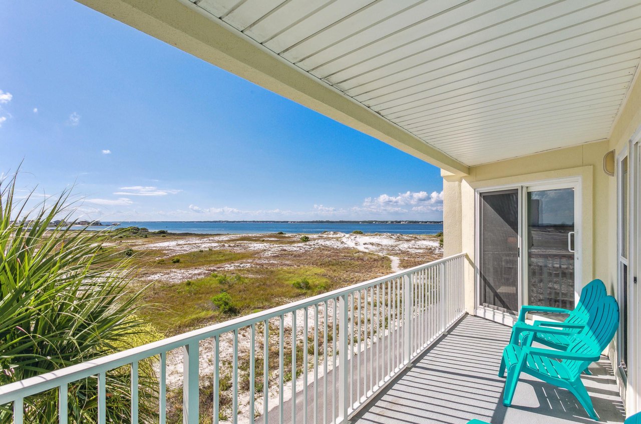 A blue loungechair on a private balcony overlooking the Santa Rosa Sound