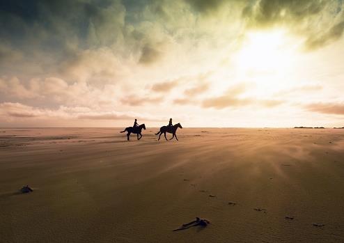 12023 People_horseback_riding_on_the_beach_at_sunset