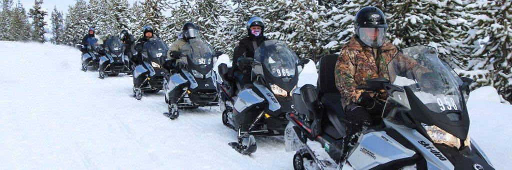 23 A Group Of People Riding Snowmobiles