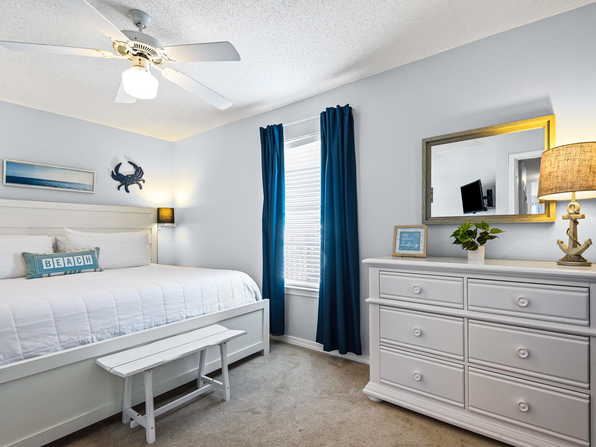The coastalthemed bedroom features crisp white linens and charming nautical touches, creating a peaceful seaside retreat for restful nights.
