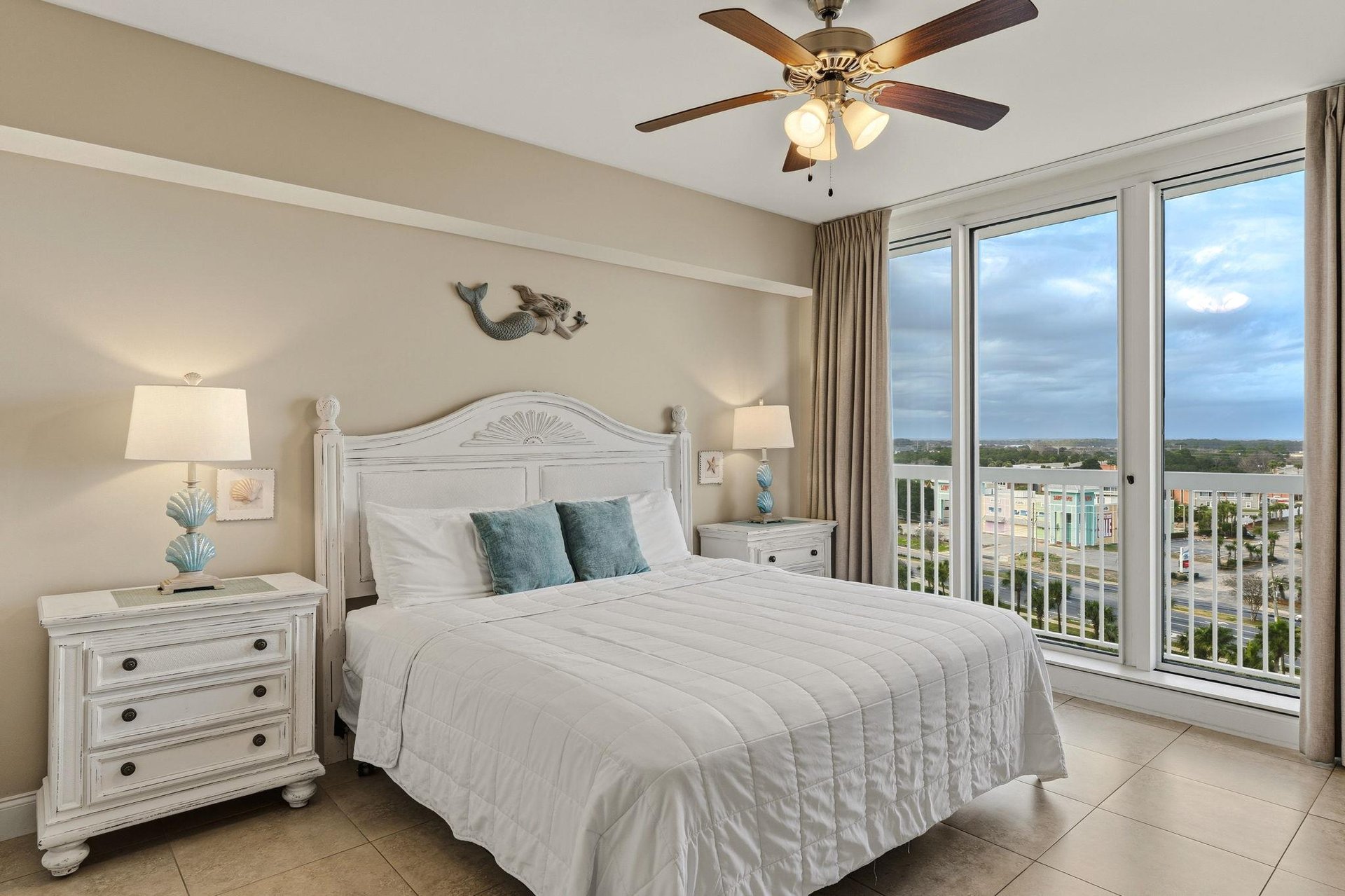 Bedroom 2 features crisp white linens and turquoise accents offering sweeping city views for peaceful mornings.