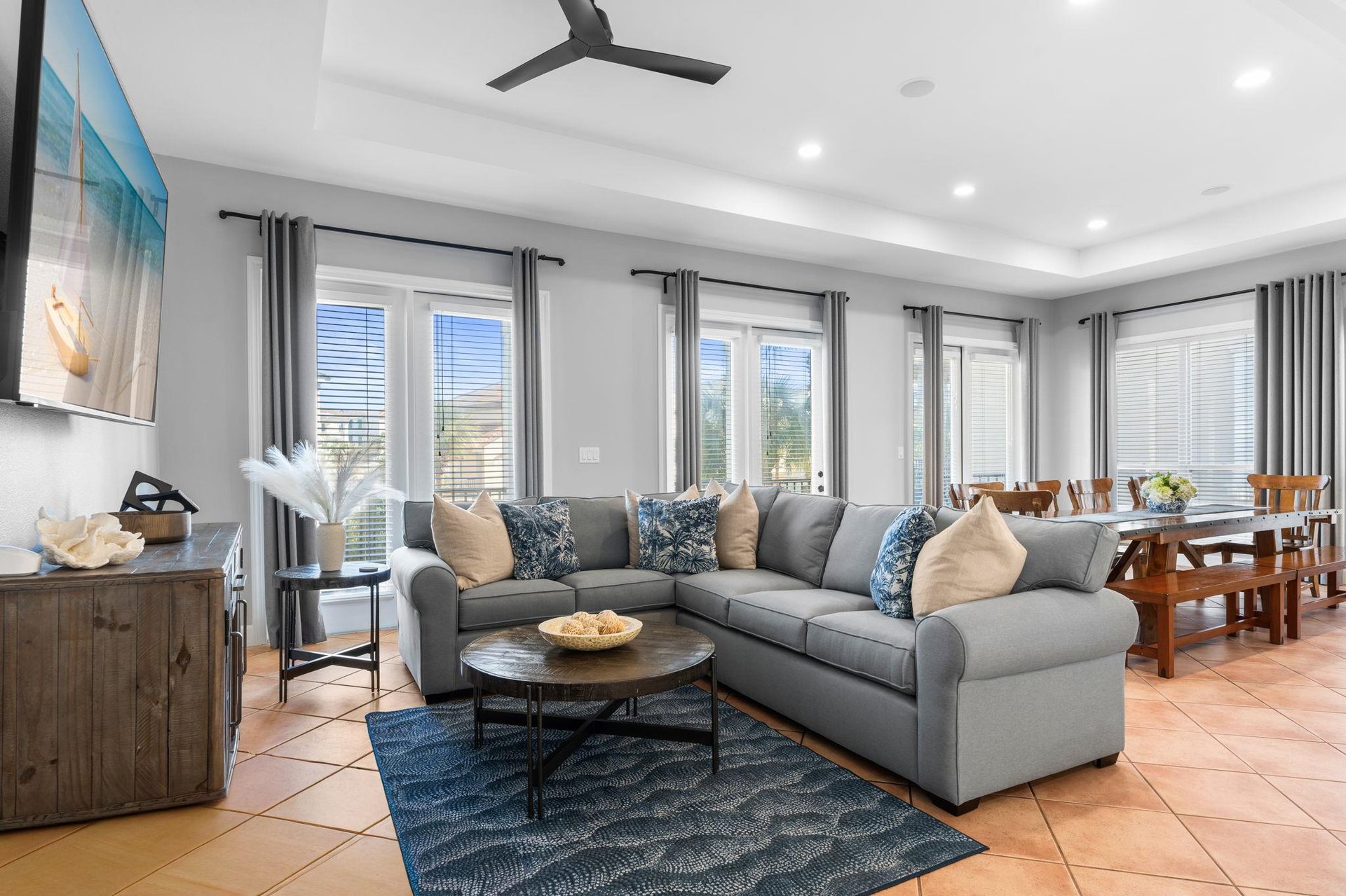 Relax in your spacious openconcept living area with plush sectional seating, natural light streaming through multiple windows, and modern comfort.