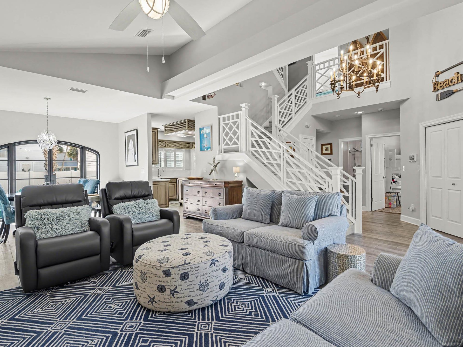 Relax in your openconcept living space featuring soaring ceilings, plush seating, and coastal charm that makes every moment feel like vacation.