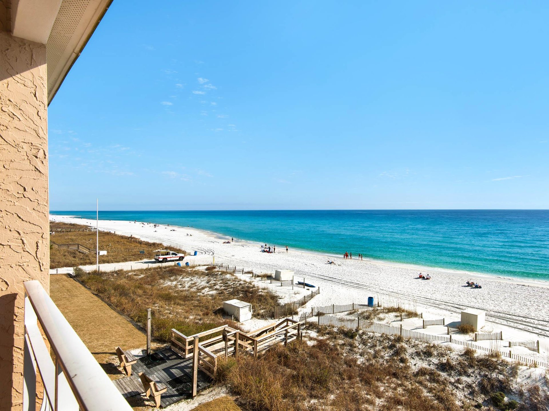 Pristine white sand beach with turquoise waters stretches endlessly beyond the property, offering direct access to Gulf Coast paradise.