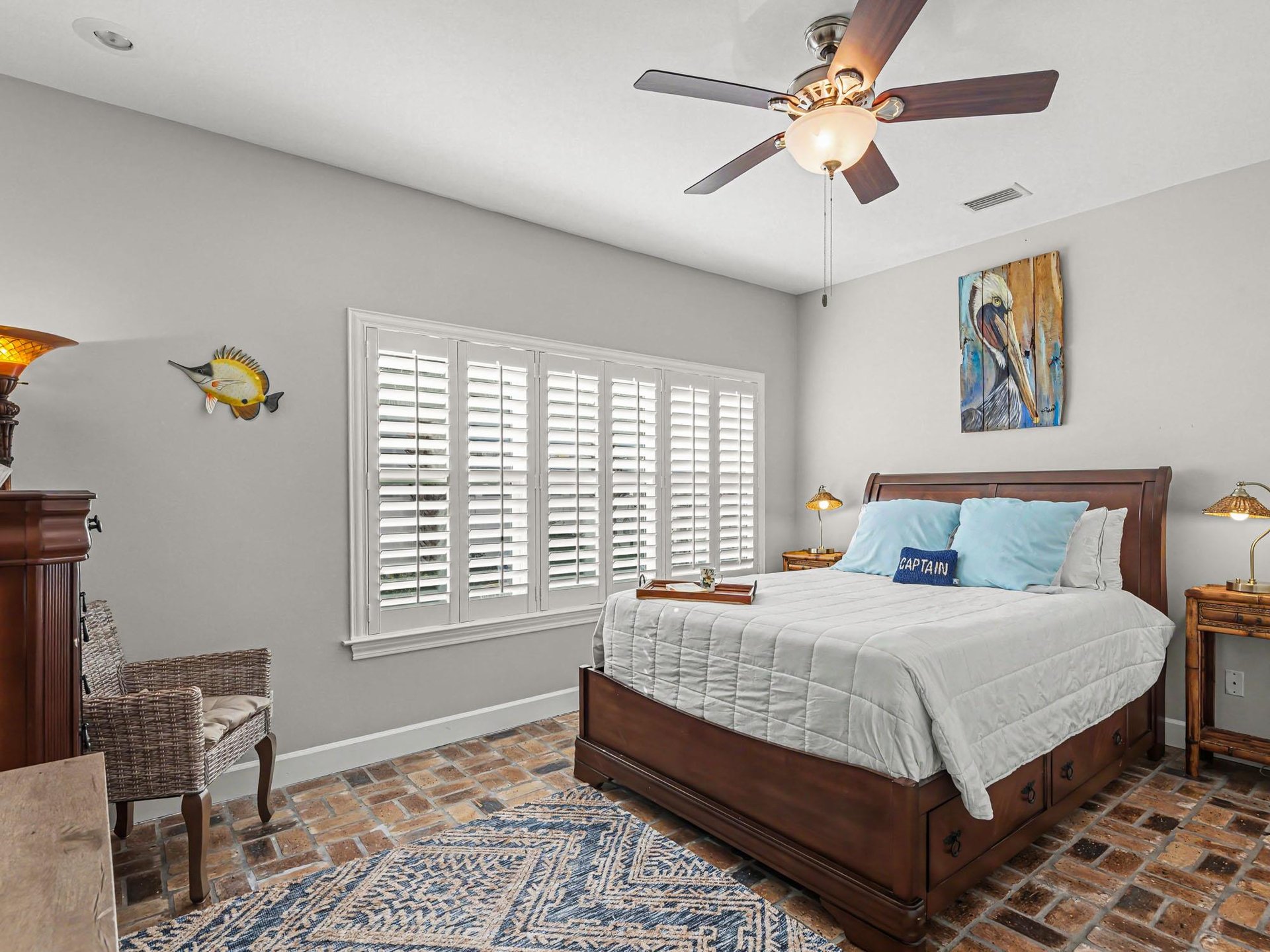 Youll feel the coastal breeze from your ceiling fan in this charming bedroom with crisp linens and nautical touches.