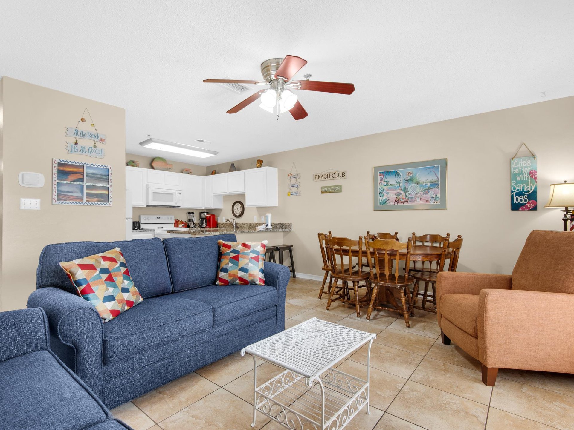Your bright openplan living space features a comfy blue sofa, dining table for six, and fully equipped kitchen—perfect for gathering with family.