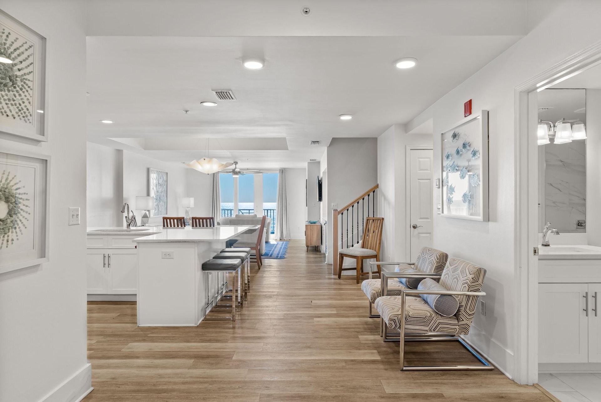 Coastal decor meets quartz countertops and stunning gulf views in this openconcept living area.