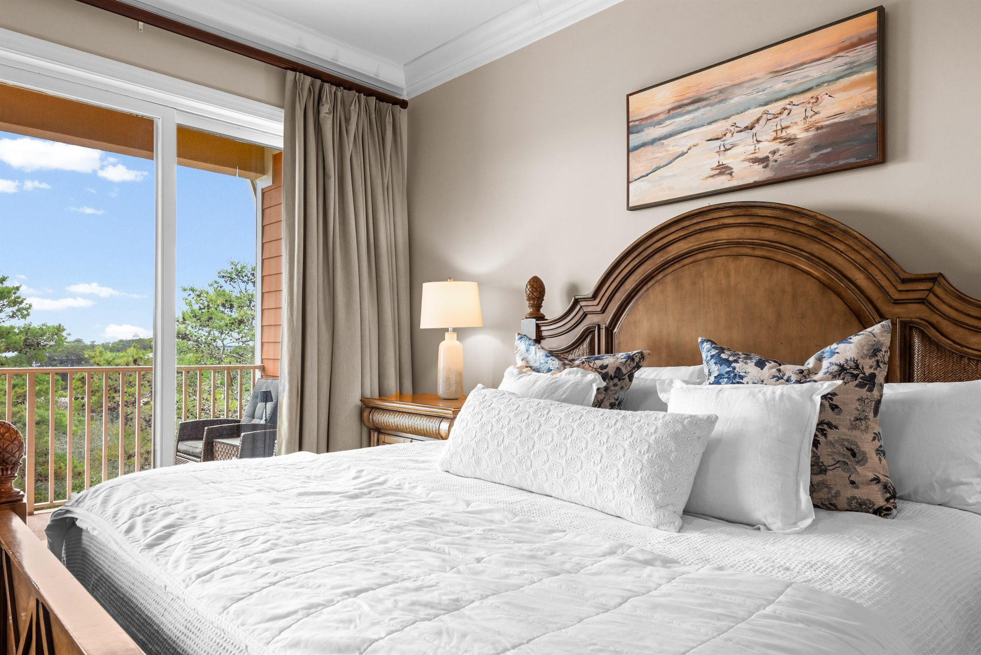 First floor king bedroom with tranquil views from your private balcony, complete with luxurious linens and coastal artwork.