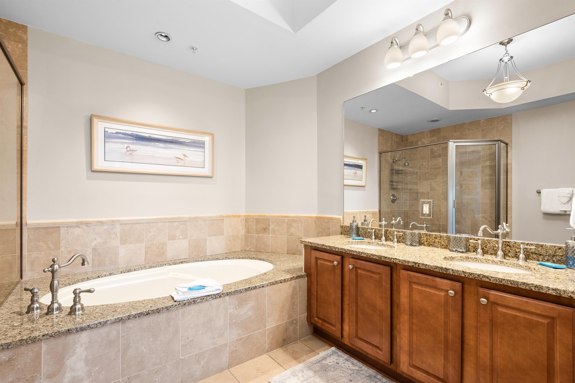 Ensuite bathroom with a deep soaking tub, granite countertops, and elegant fixtures designed for ultimate relaxation.