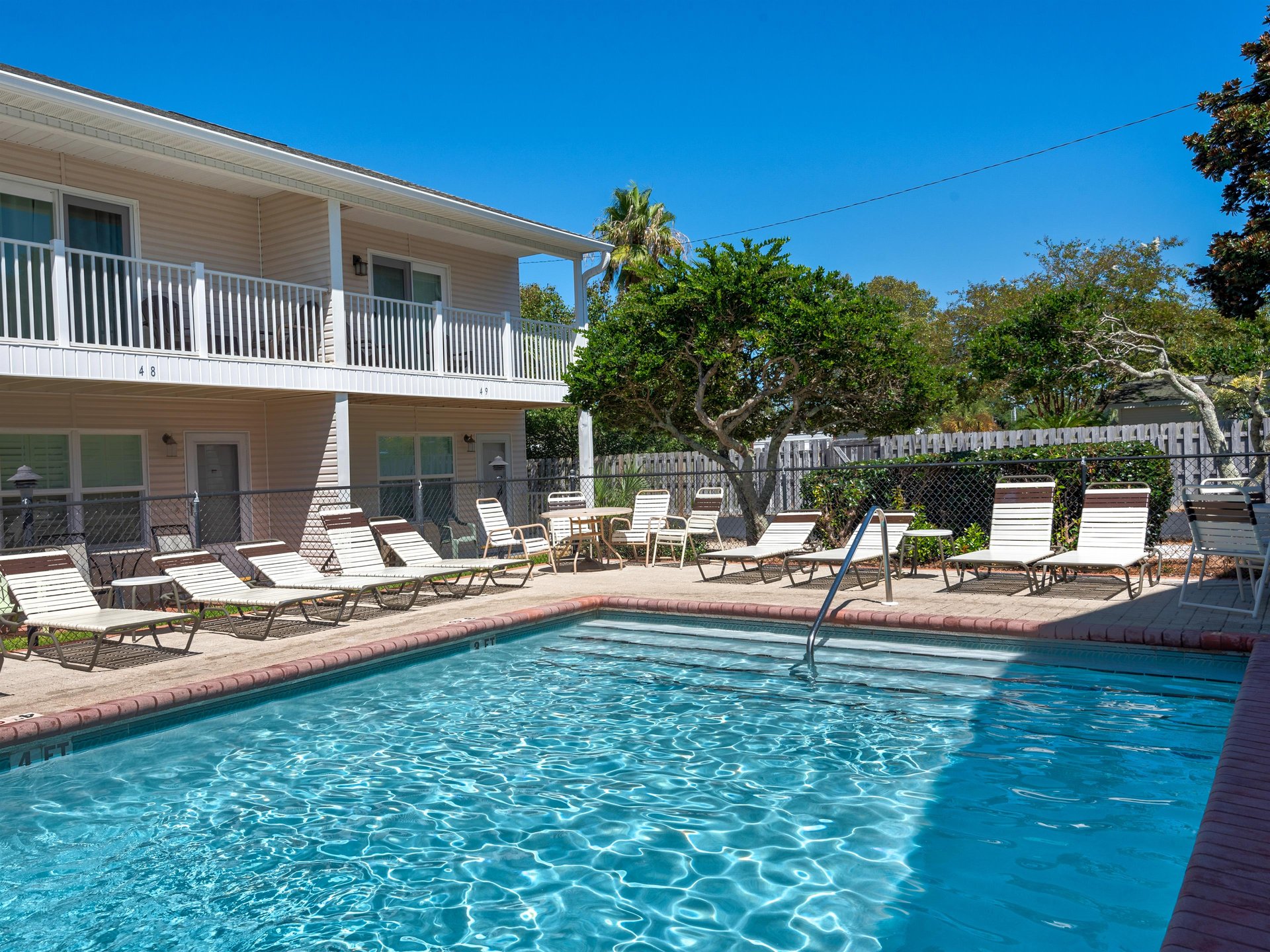 The sparkling community pool surrounded by comfortable loungers awaits you