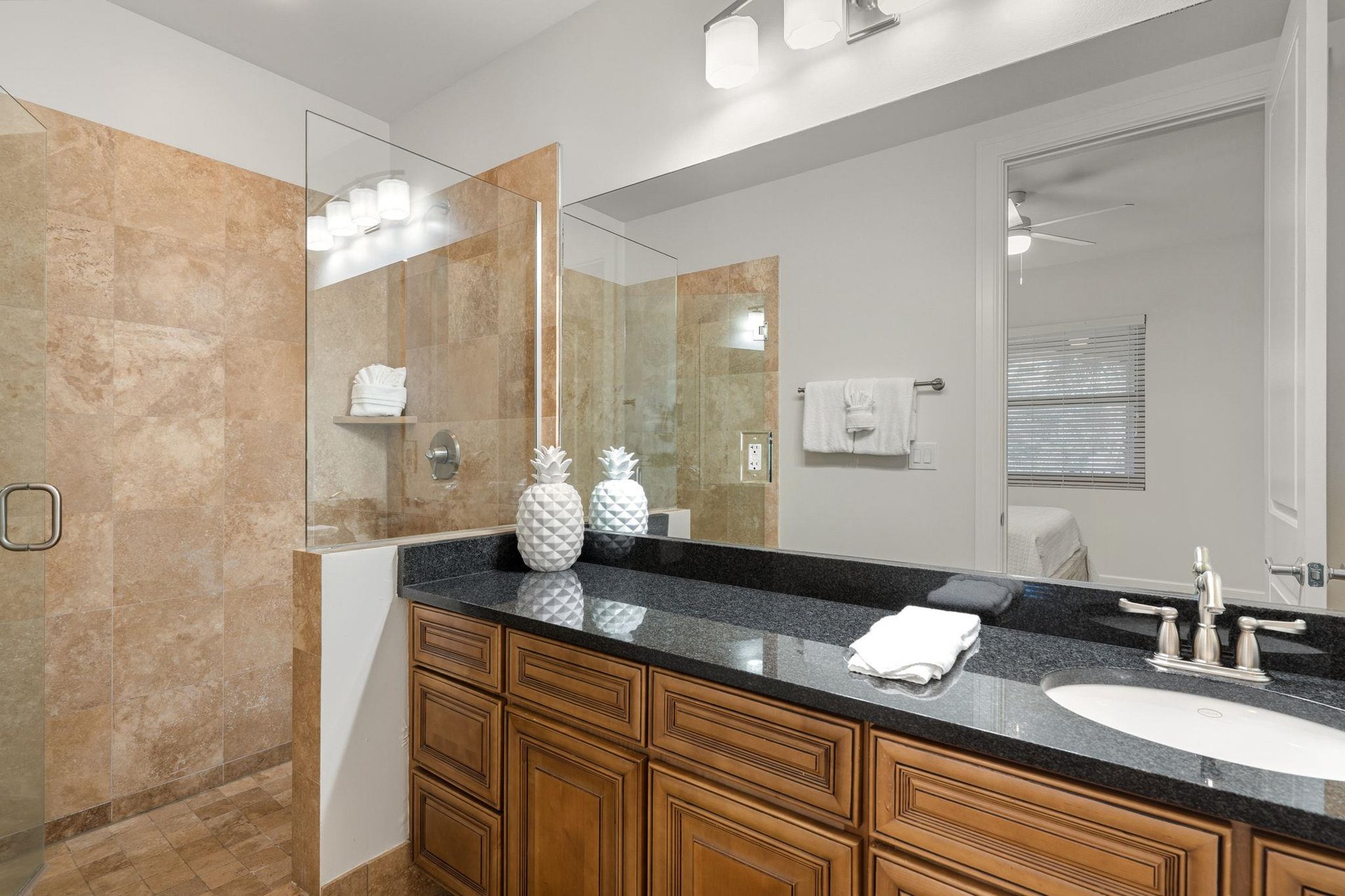 Private spalike bathroom with luxurious granite counters, and elegant travertine shower.