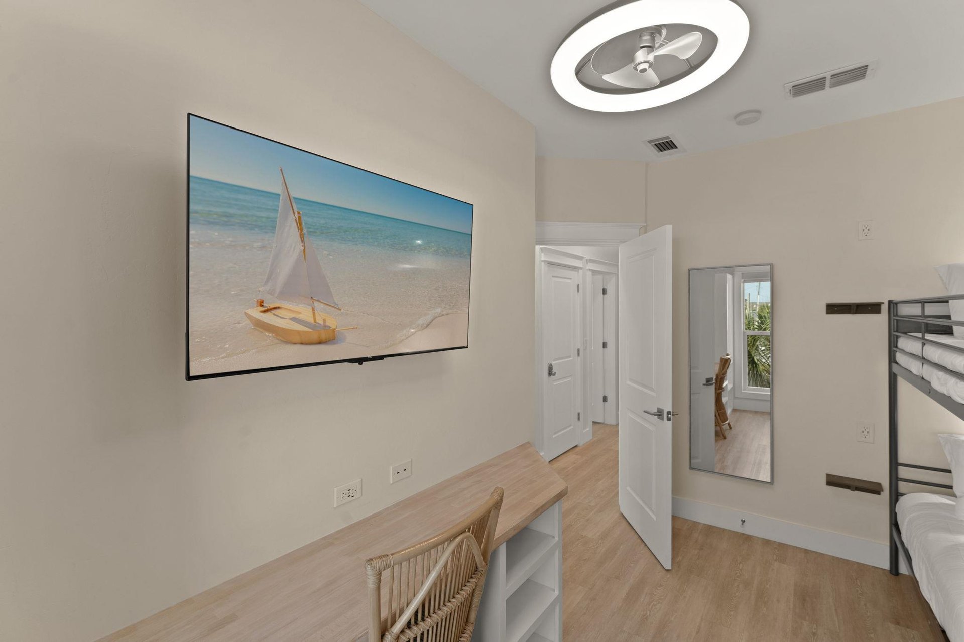 Unwind in your bright modern room with a large TV and peaceful coastal artwork adorning the walls.