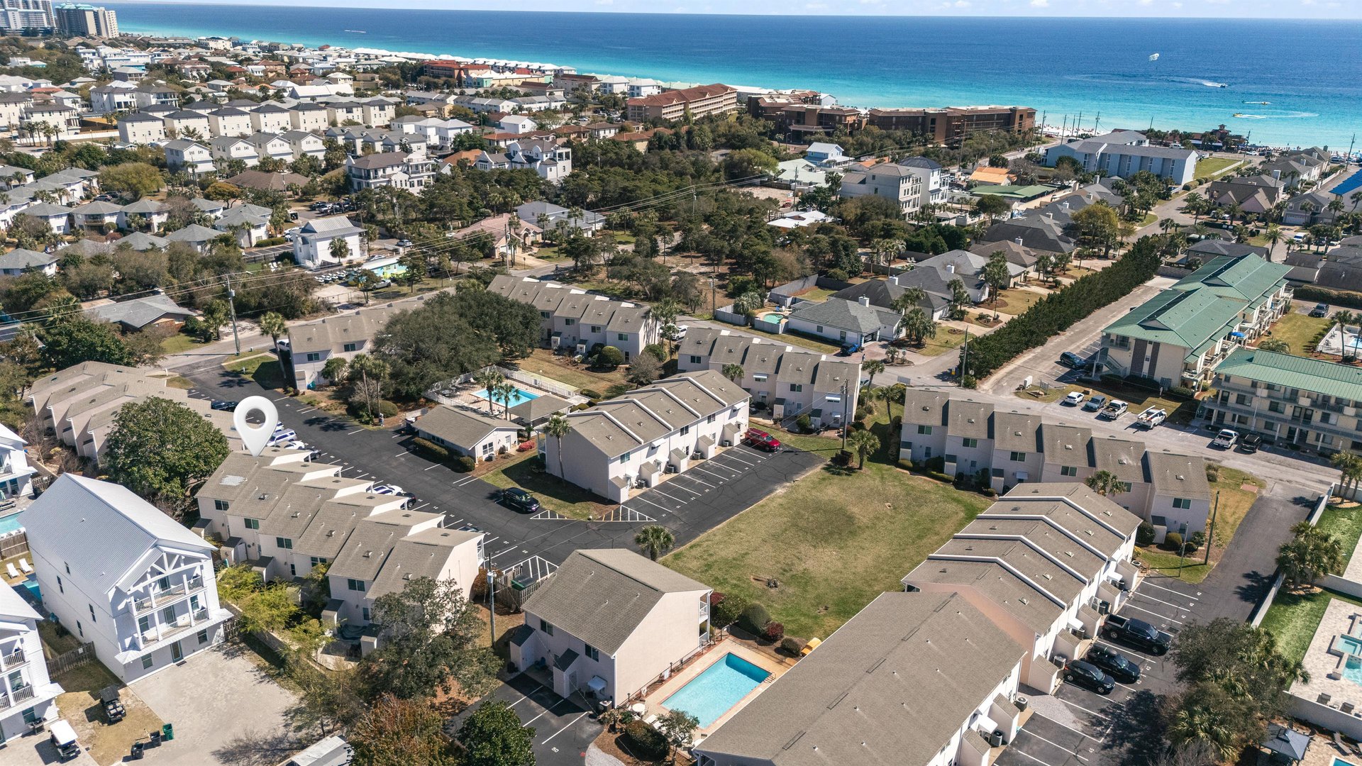 Aerial view of beachside vacation rental community with pristine turquoise waters and white sand beaches just moments away from your stay.