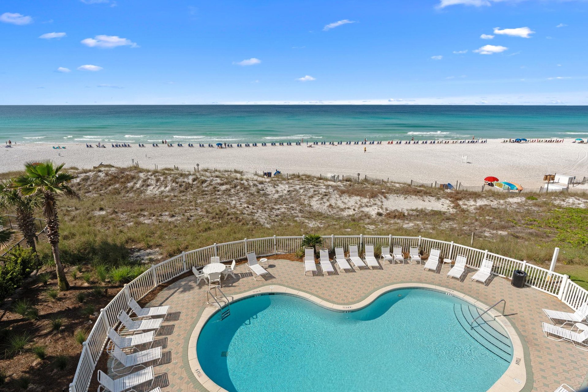 Coastal property featuring pool access and beachfront location with pristine white sand and turquoise waters stretching to the horizon.