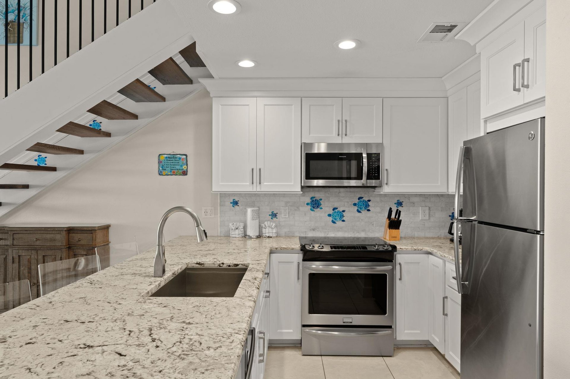 Your bright, modern kitchen features granite countertops, stainless steel appliances, and charming coastal decor—perfect for preparing meals or brewing morning coffee in your home away from home.
