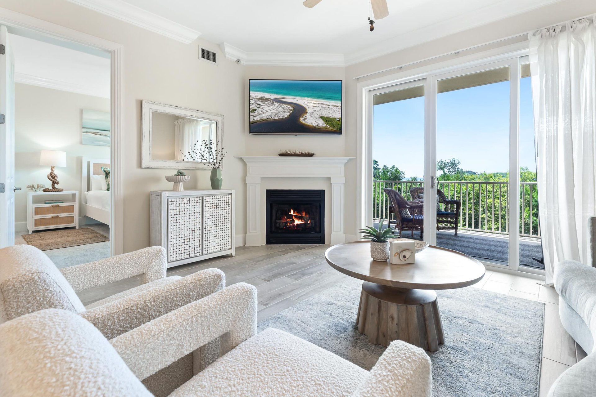 Step into your bright, coastalchic living room where plush seating and a cozy fireplace invite you to relax after sunsoaked days. Large windows frame your private balcony views of endless greenery.