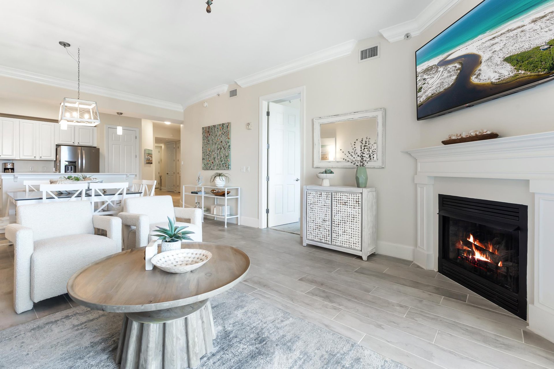 Unwind in your spacious openconcept living area, complete with a cozy fireplace, modern kitchen, and coastal décor that invites relaxation and memorable gatherings.