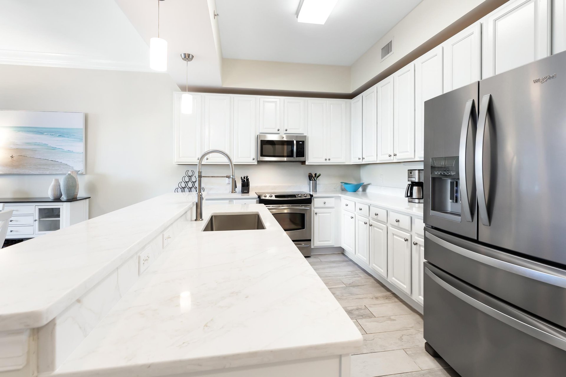 Your fully equipped kitchen features gleaming quartz countertops, stainless steel appliances, and bright white cabinetry—perfect for preparing everything from quick breakfasts to memorable vacation di