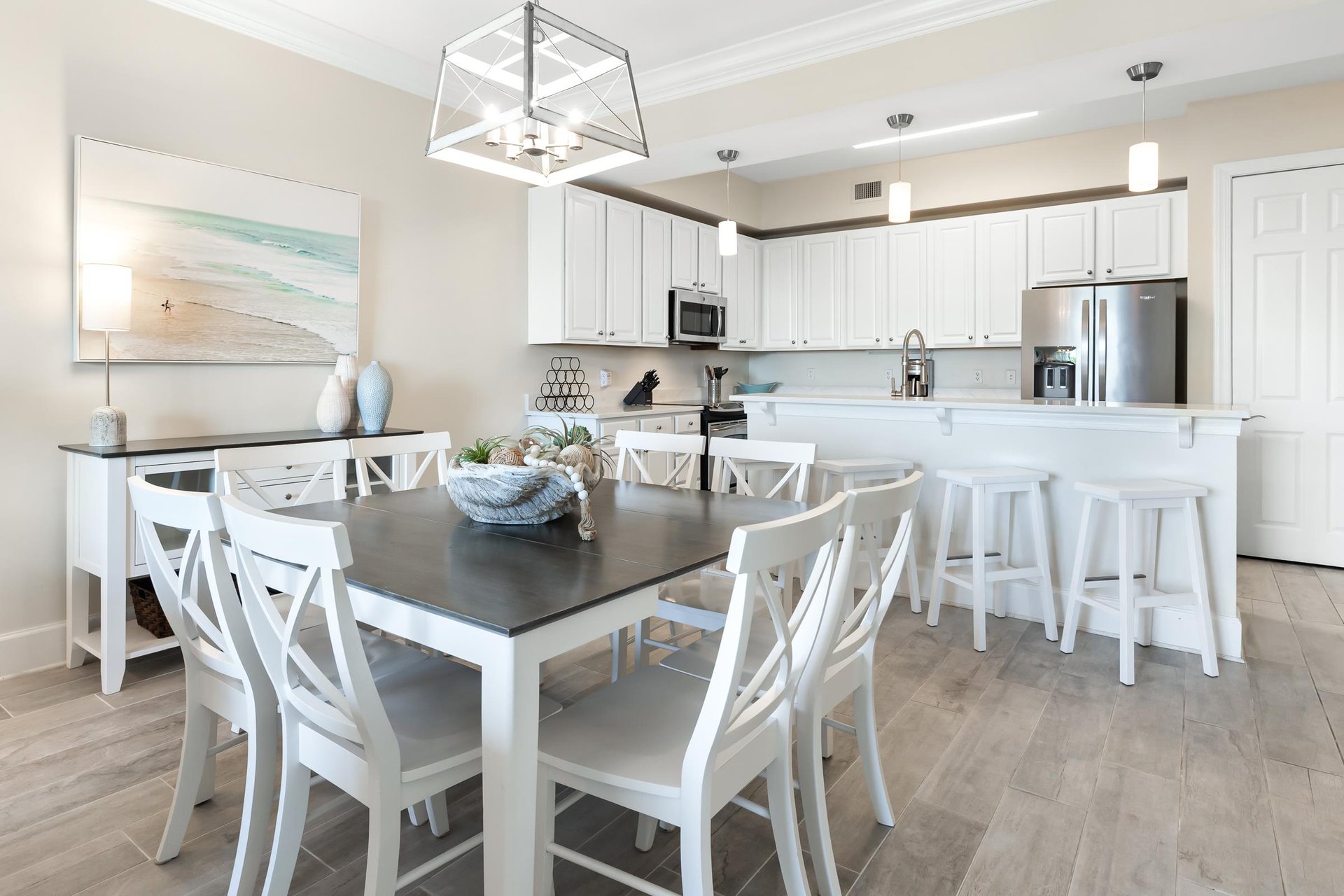 Gather around this bright, coastalinspired dining space and fully equipped kitchen, where white cabinetry and modern appliances set the stage for your meals and memories together.