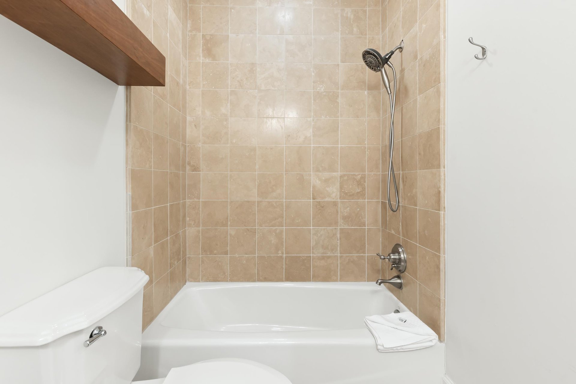 Step into your private bathroom featuring a tubshower combo with elegant beige tile, perfect for unwinding after a day of adventure.