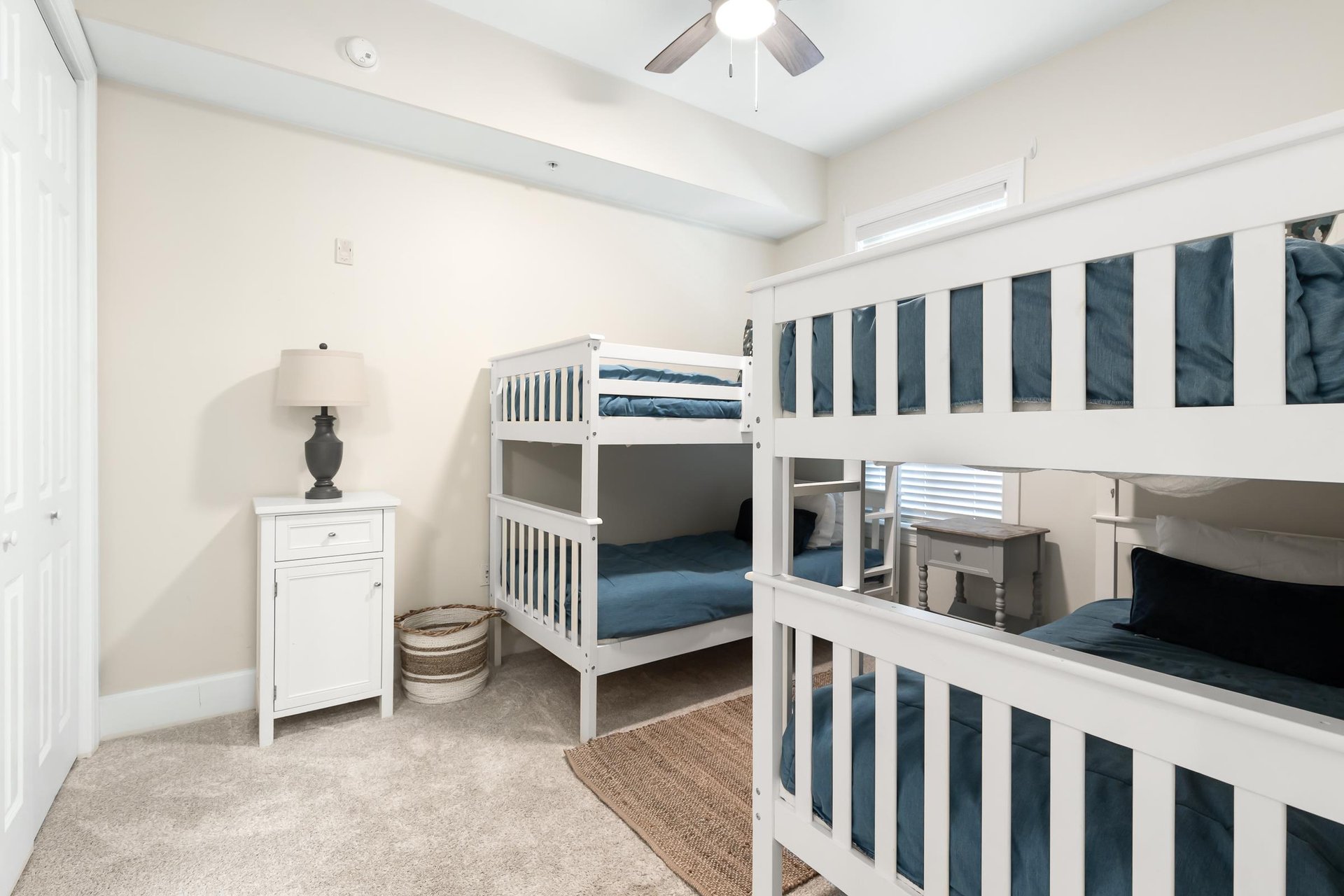 Bright bedroom with two white bunk beds, perfect for the kids to enjoy their own cozy retreat during your family getaway.