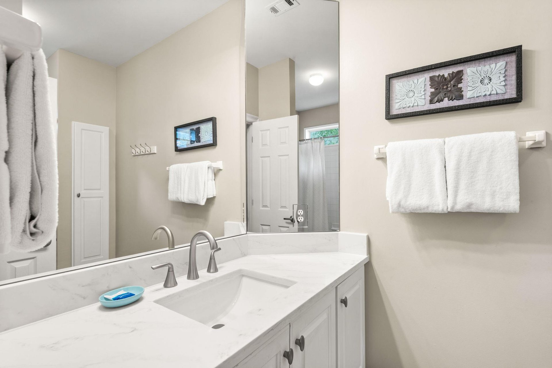 Freshen up in the bathroom, complete with a vanity sink, gleaming countertops, and plush white towels,
