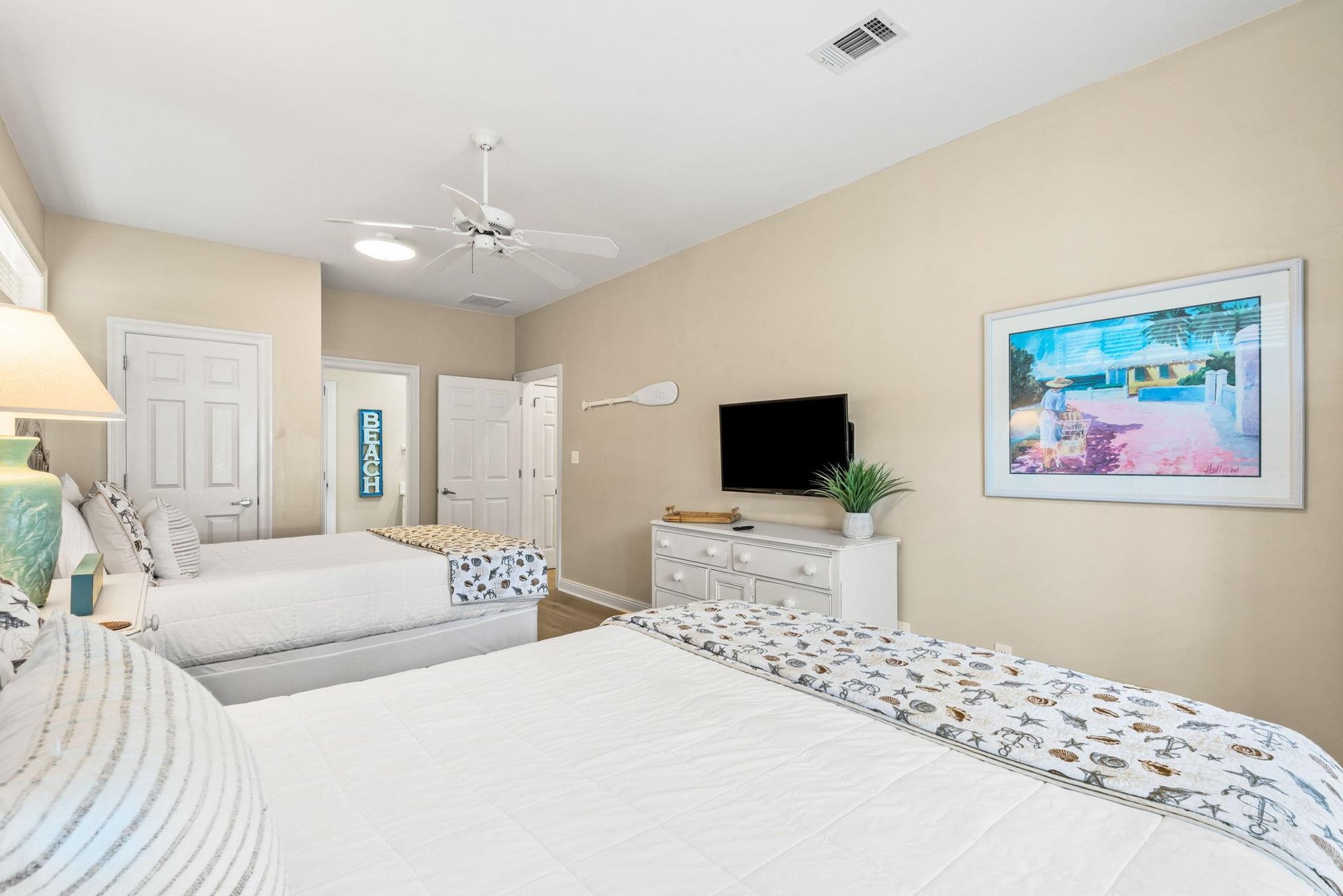 Along with two queen beds, enjoy modern comforts like a flatscreen TV, ceiling fan, and peaceful beachthemed décor.