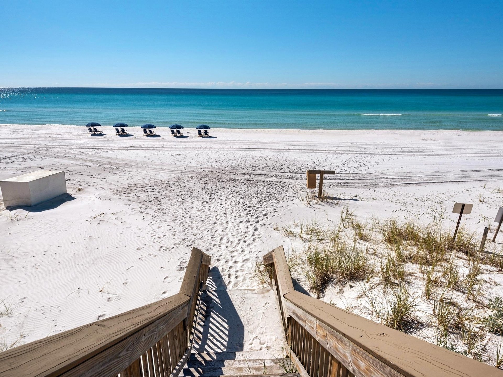 Private boardwalk leads directly to pristine white sand beach and crystalclear turquoise waters under sunny skies, offering easy access to your coastal escape.