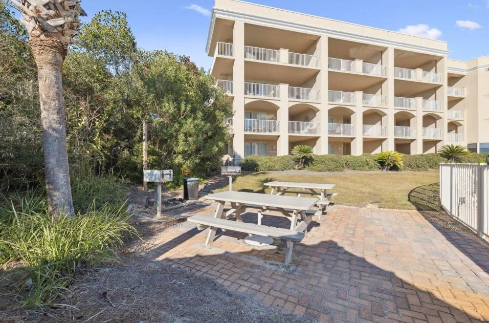 The property building features balconies overlooking lush tropical landscaping and a convenient picnic area with shaded seating—perfect for outdoor relaxation.