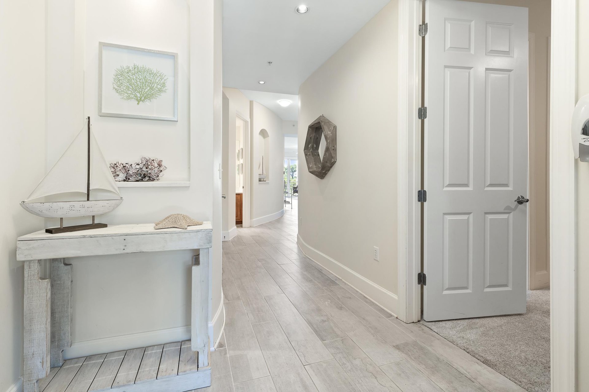 Step inside your serene coastal retreat, where whitewashed wood and nautical touches welcome you into a peaceful haven. The lightfilled hallway invites you to unwind and discover your home away from 