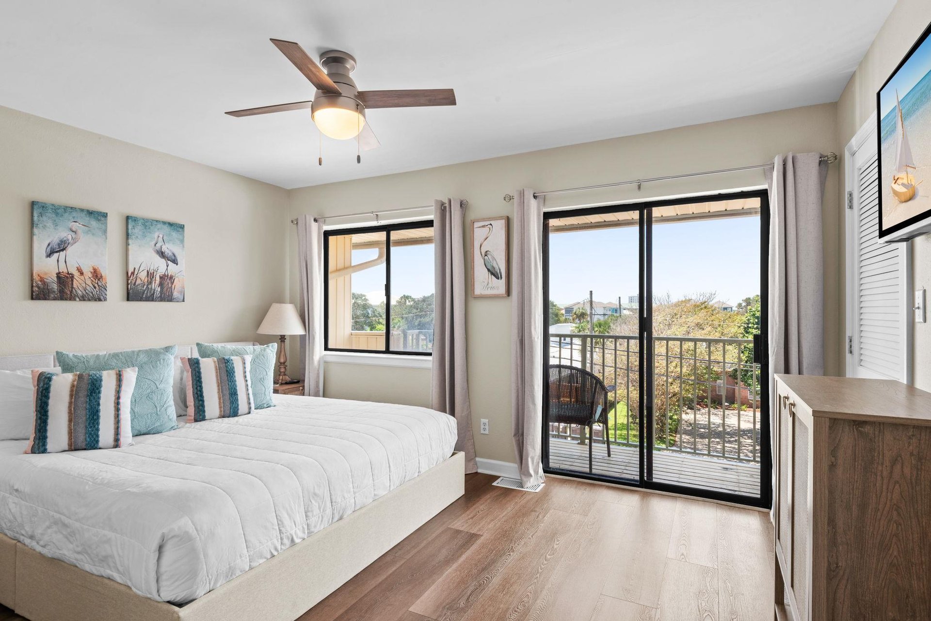 Your serene bedroom features a ceiling fan, crisp white linens, and calming coastal décor.