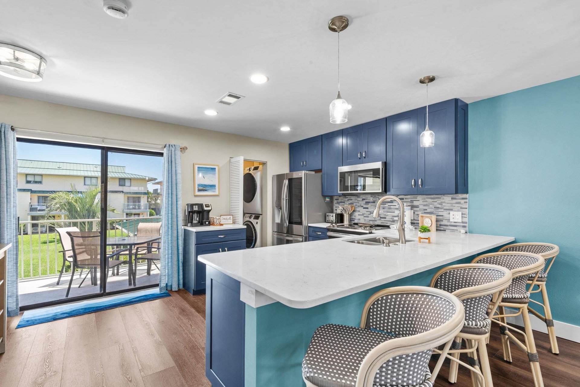 Enjoy this stylish kitchen island with friends and family, where modern blue cabinetry and sleek stainless appliances make cooking a joy.