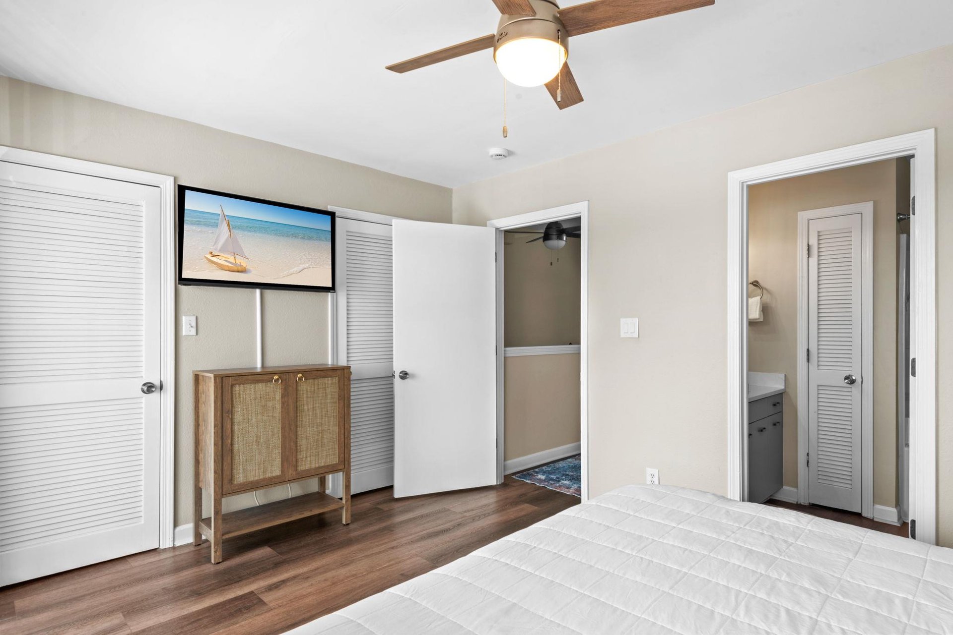 Your peaceful bedroom features a ceiling fan, wood flooring, and convenient closet access, with an ensuite bathroom just steps away for your comfort.