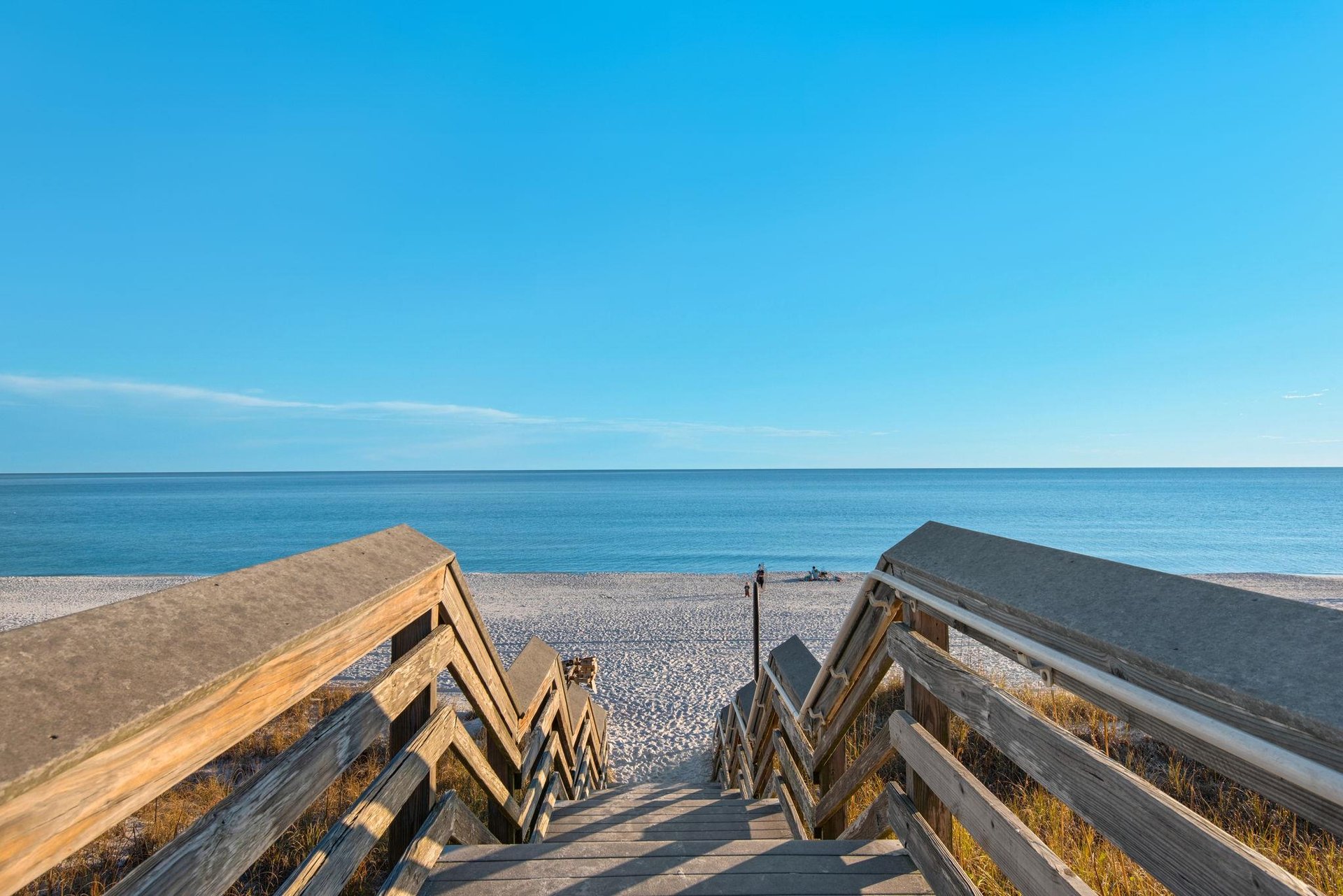 Follow this charming boardwalk down to your own slice of coastal paradise, where soft white sand and endless blue horizons await.