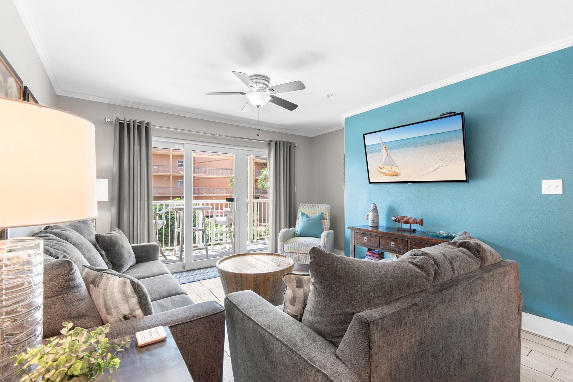 Unwind in your bright living room with plush seating, breezy ceiling fan, and coastal touches that set the tone for your beach getaway.