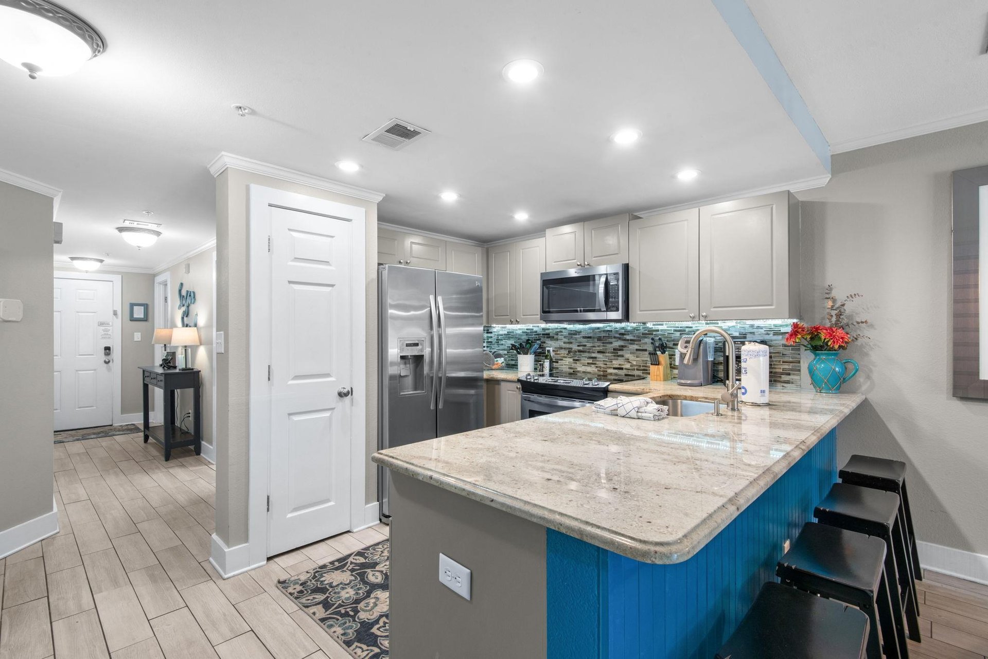 Fully equipped kitchen with granite countertops, stainless appliances, and a spacious island perfect for meal prep or gathering over morning coffee.