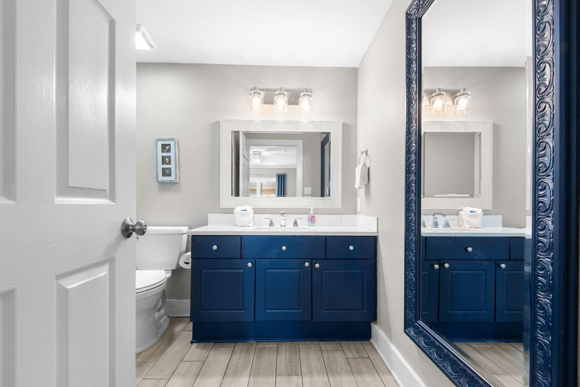 Step into your spalike bathroom where a bold navy vanity meets soft gray walls and gleaming fixtures. Freshen up at the spacious counter with plenty of natural light flowing in.