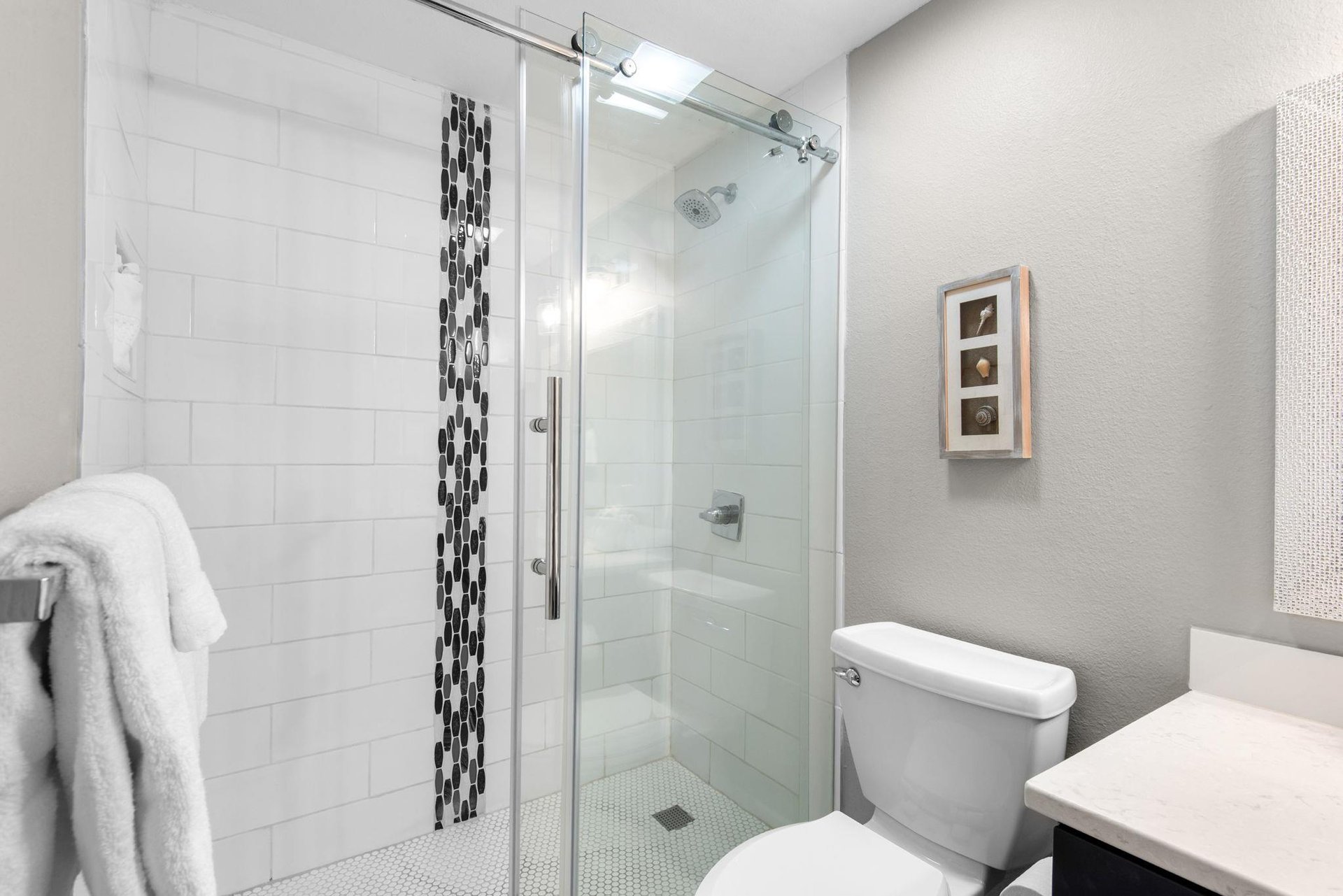 Refresh in your stylish, modern bathroom with a spacious walkin shower and crisp white subway tiles.