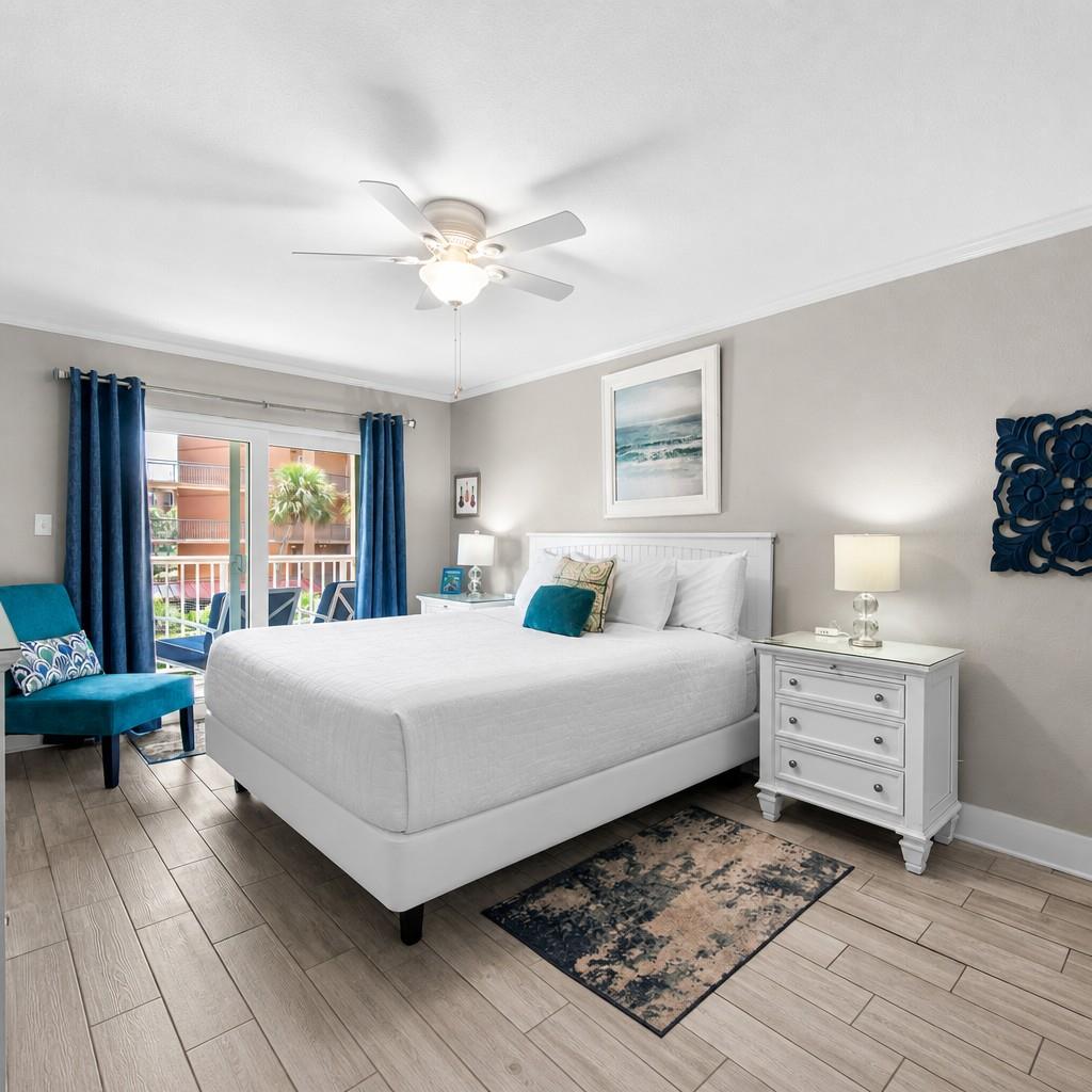 Serene primary bedroom where a plush king bed awaits, framed by soothing coastal tones. Soft lighting and beachy artwork set the mood for your restful retreat.