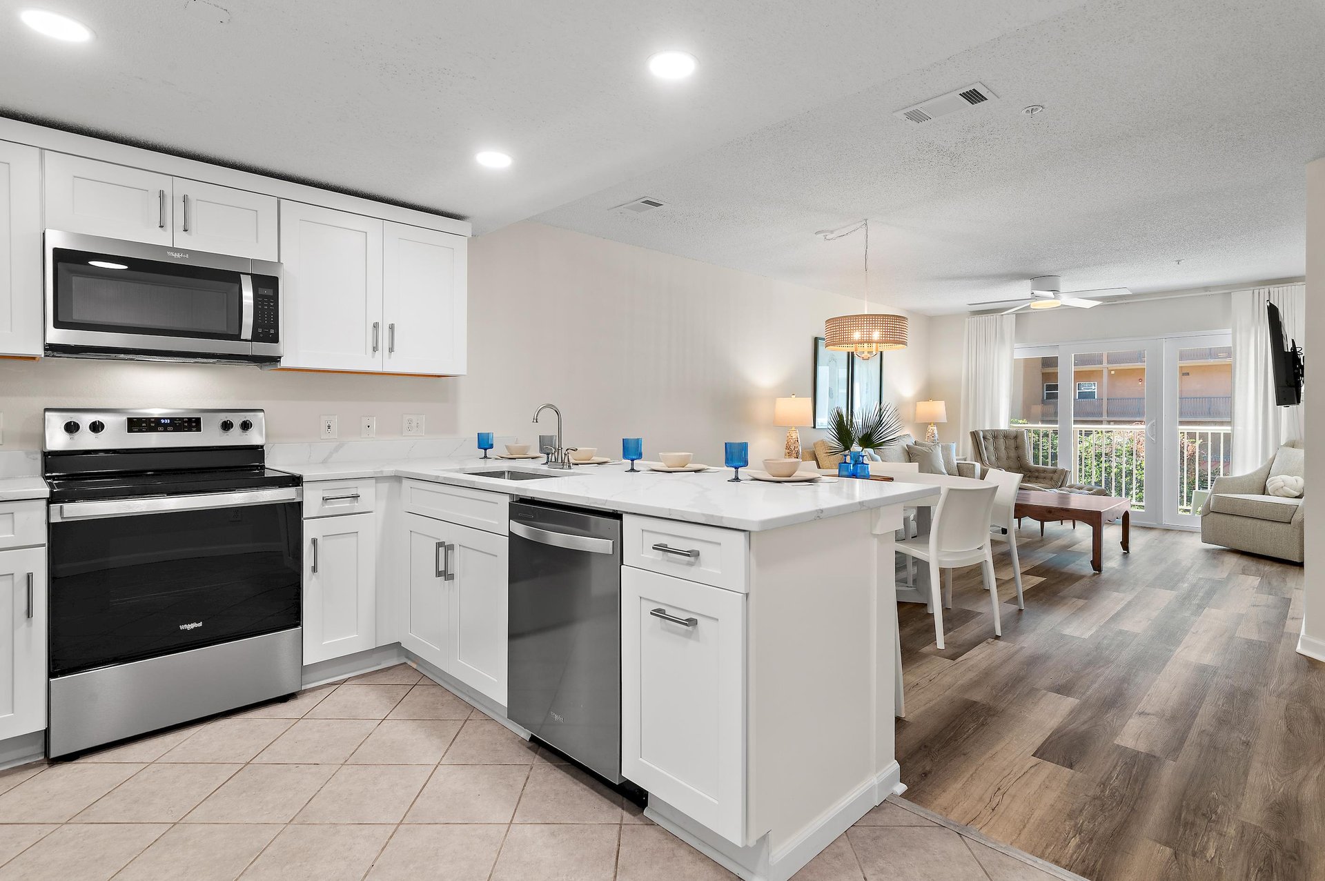 Step into your bright, openconcept space where cooking and gathering blend seamlessly. The modern kitchen flows into a welcoming dining and living area, with natural light streaming through the glass