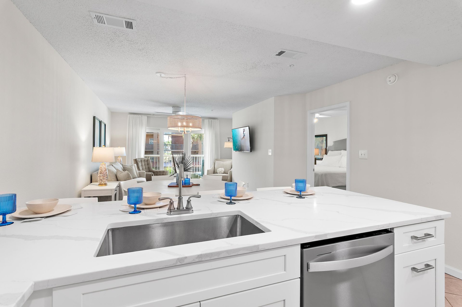Sleek white countertops and stainless appliances set the stage for easy meal prep, with the bright, inviting living space and your restful bedroom just steps away.