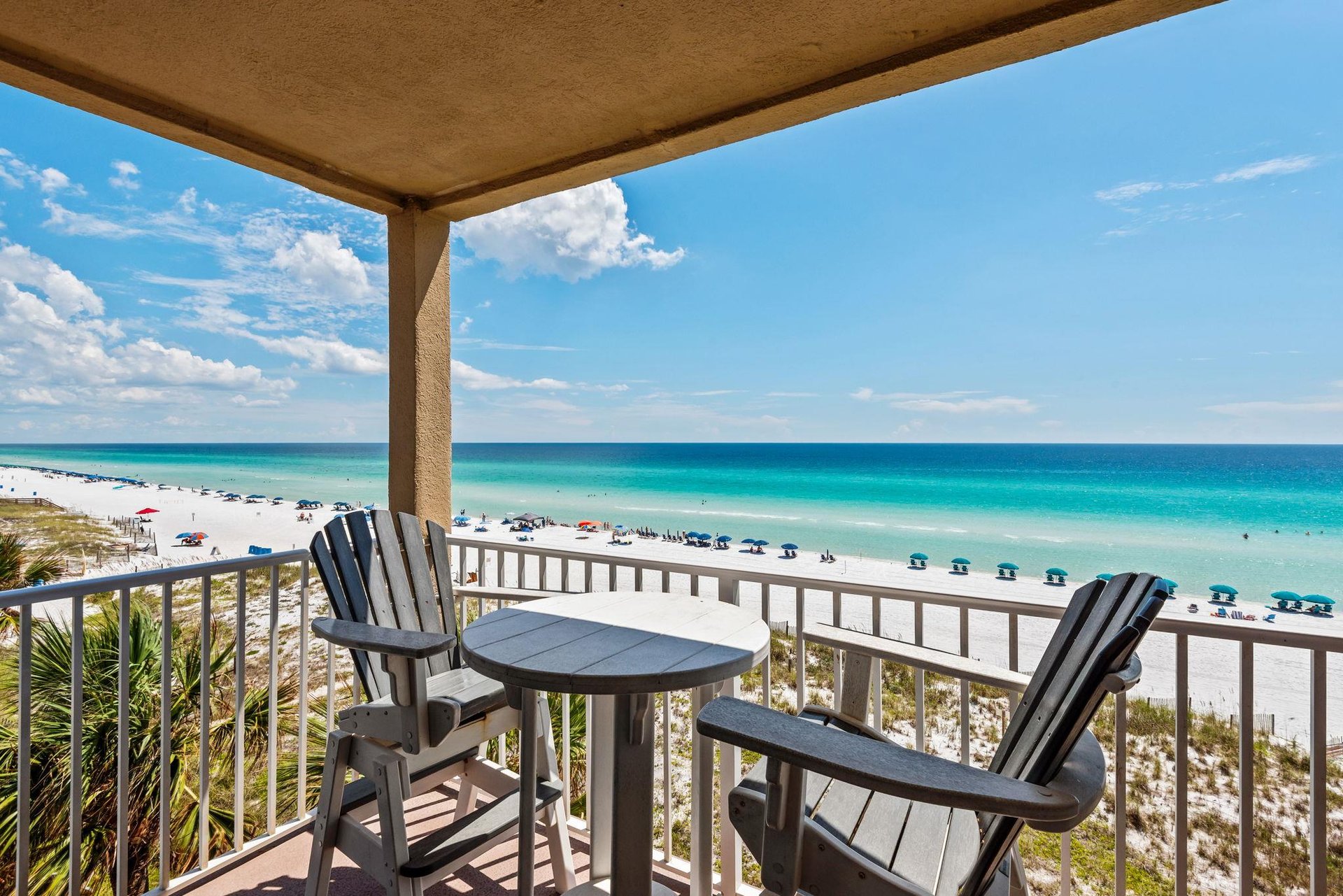 The private balcony offers stunning views of emerald waters and sugarwhite sand.