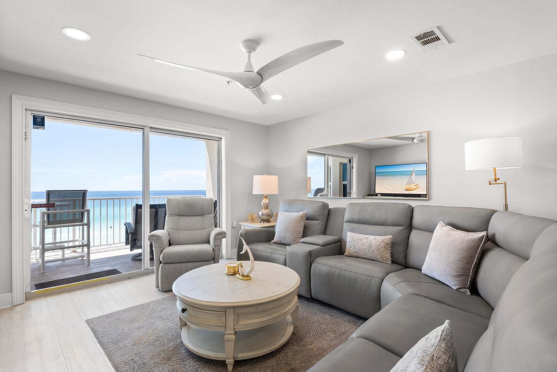 Sink into this inviting living room and let the ocean breezes drift through your balcony door. Soft seating and coastal details make this your perfect retreat after a day by the water.